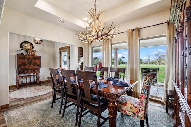812 Mckenzie Rd, Tioga, TX 76271 - dining area featuring visible vents, a chandelier, wood finished floors, a raised ceiling, and baseboards