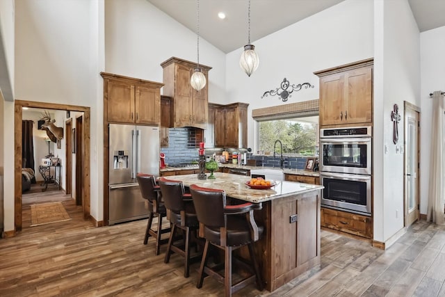 812 Mckenzie Rd, Tioga, TX 76271 - kitchen with tasteful backsplash, appliances with stainless steel finishes, wood finished floors, and a kitchen island