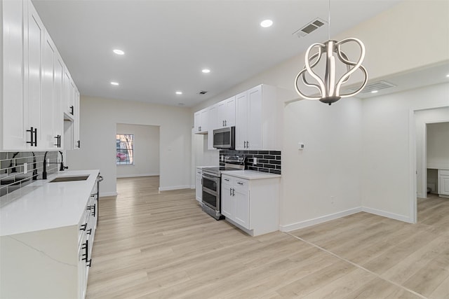 kitchen featuring light stone countertops, sink, white cabinets, and stainless steel appliances