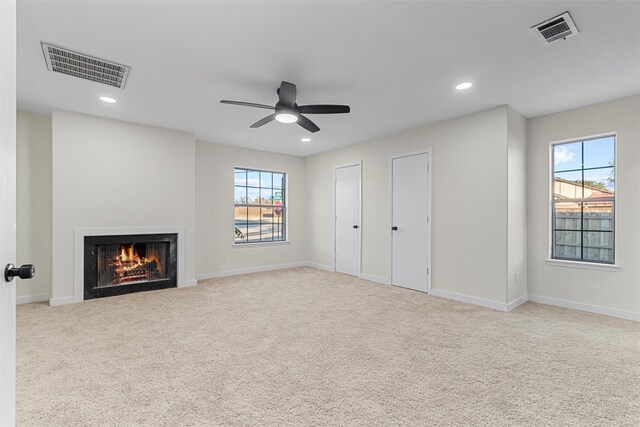 unfurnished living room with light carpet and ceiling fan