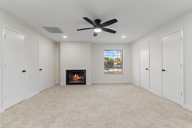 unfurnished living room featuring light carpet and ceiling fan