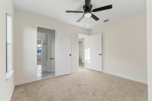 unfurnished bedroom with ceiling fan and light colored carpet