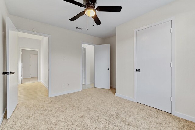 unfurnished bedroom featuring ceiling fan and light carpet