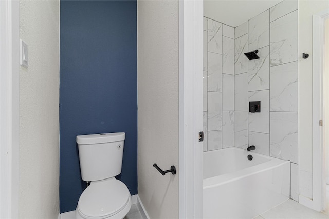 bathroom with tile patterned flooring, tiled shower / bath combo, and toilet