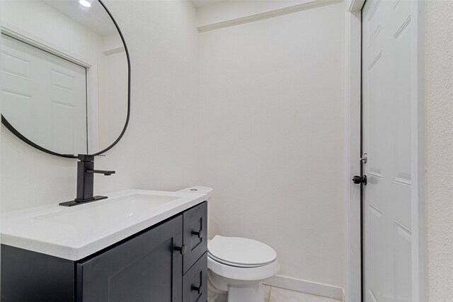 bathroom with tile patterned floors, vanity, and toilet