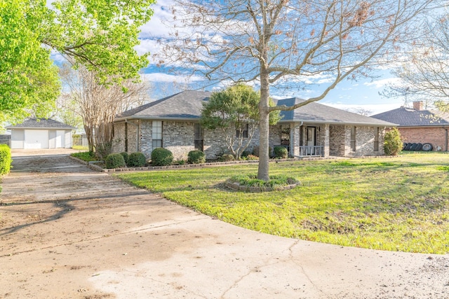 ranch-style home featuring a garage, an outdoor structure, and a front yard