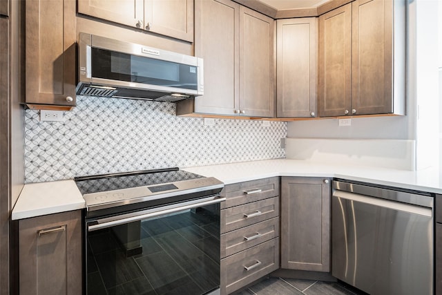 kitchen featuring dark tile patterned flooring, backsplash, and stainless steel appliances