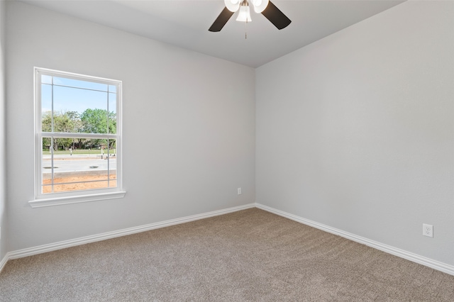 carpeted spare room featuring ceiling fan