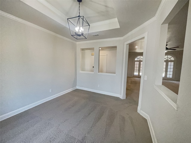 carpeted spare room with a raised ceiling, ornamental molding, and ceiling fan with notable chandelier