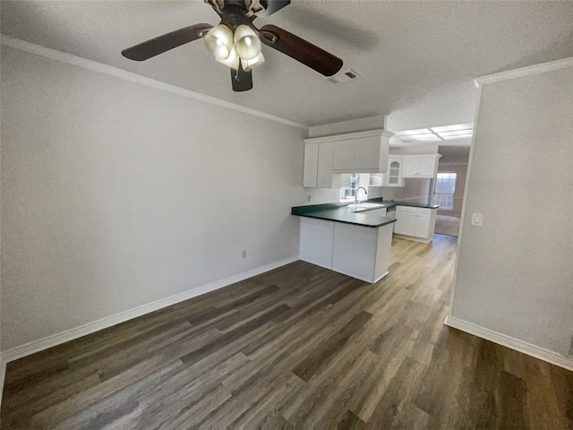 kitchen featuring white cabinetry, ceiling fan, sink, dark hardwood / wood-style flooring, and ornamental molding