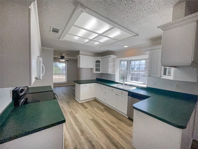 kitchen with a healthy amount of sunlight, white cabinetry, light wood-type flooring, and sink