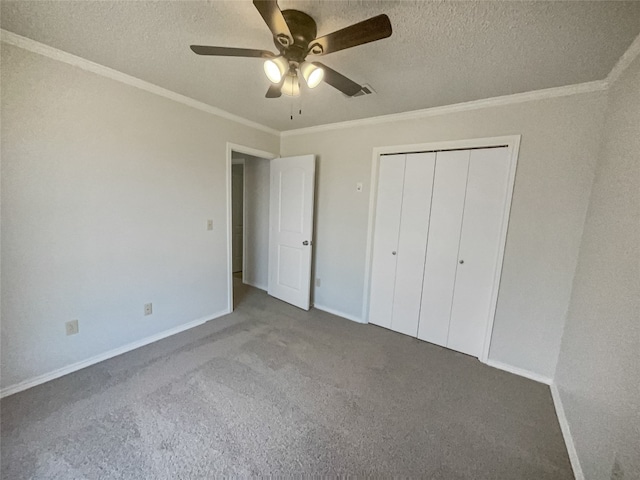 unfurnished bedroom featuring dark colored carpet, a closet, ceiling fan, and crown molding