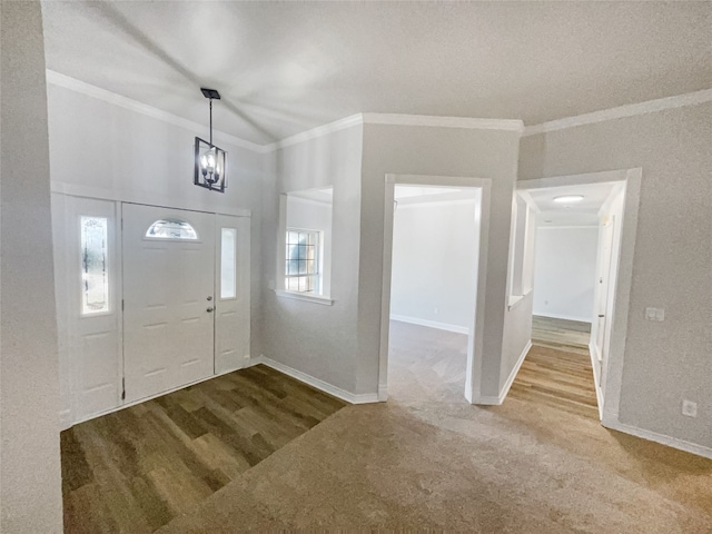 carpeted foyer with ornamental molding and a notable chandelier