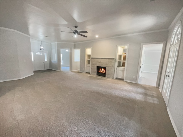 unfurnished living room with crown molding, carpet, and ceiling fan