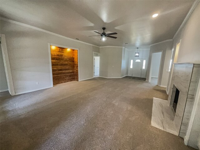 unfurnished living room with crown molding, ceiling fan, and carpet