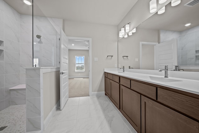 bathroom with tiled shower and vanity