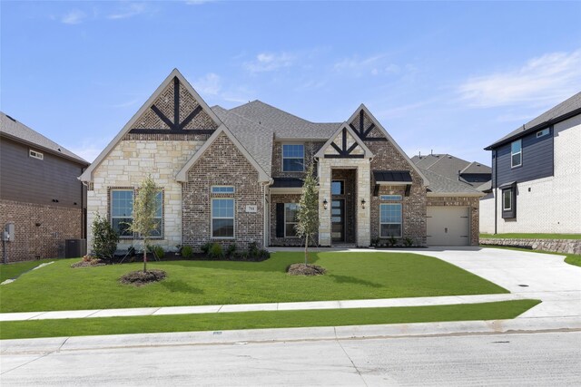 view of front of property with a front yard, central AC, and a garage