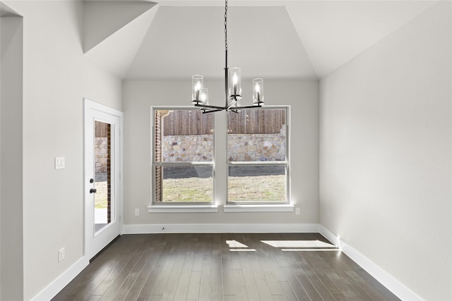 unfurnished dining area featuring vaulted ceiling, dark hardwood / wood-style floors, and a chandelier