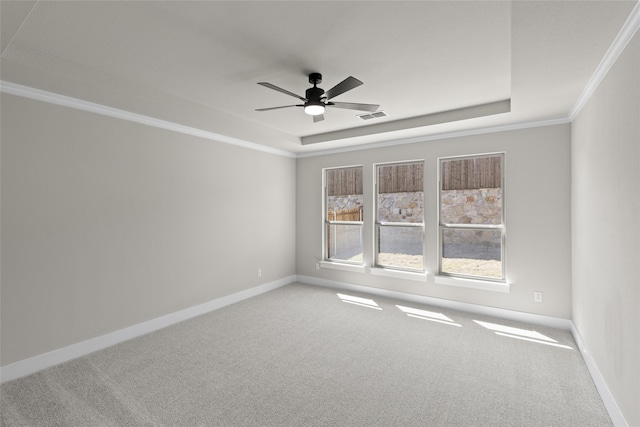 carpeted empty room featuring a raised ceiling, crown molding, and ceiling fan