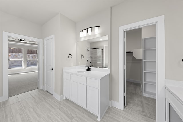 bathroom featuring ceiling fan, vanity, and a shower with shower door