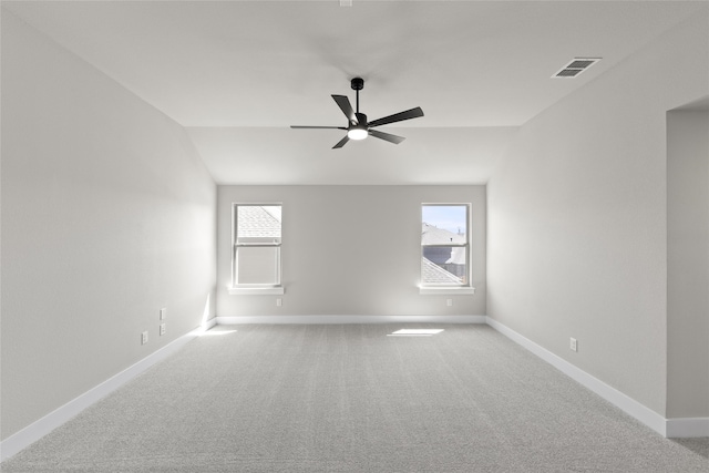 carpeted spare room featuring vaulted ceiling and ceiling fan