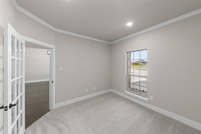 spare room with crown molding and dark colored carpet