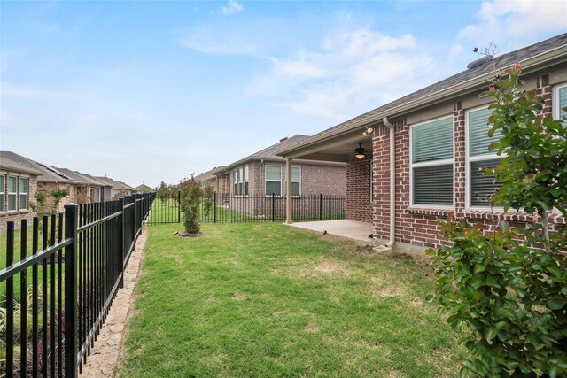 view of yard with ceiling fan and a patio