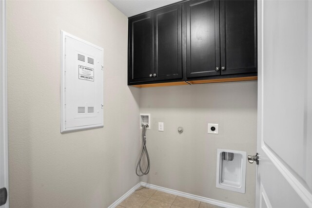 laundry area featuring washer hookup, light tile patterned floors, hookup for an electric dryer, hookup for a gas dryer, and cabinets