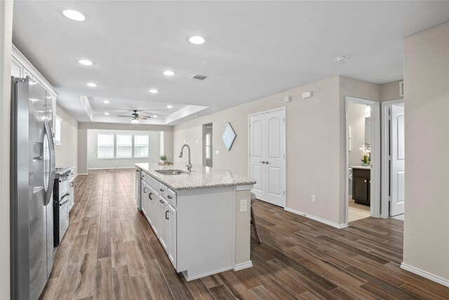 kitchen with appliances with stainless steel finishes, sink, an island with sink, and white cabinets