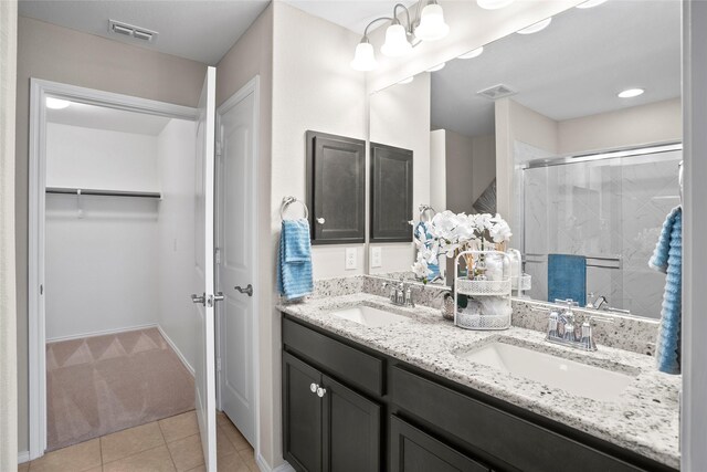 bathroom featuring vanity, a shower with door, and tile patterned floors