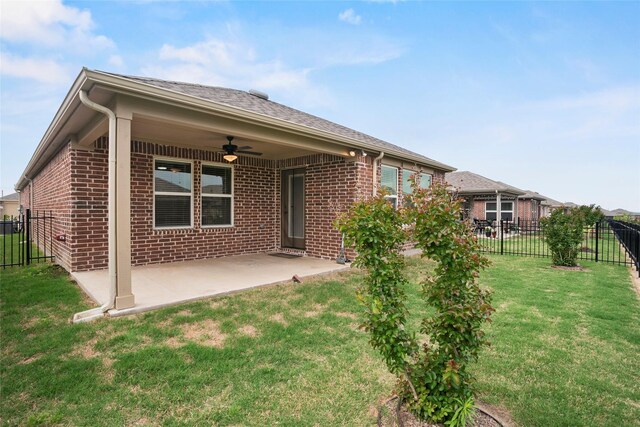 rear view of property featuring a yard, a patio, and ceiling fan