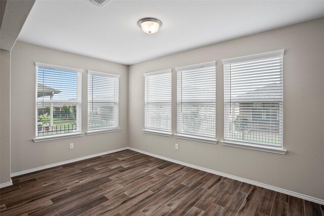 unfurnished room with dark wood-type flooring