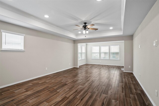 empty room featuring ceiling fan, dark hardwood / wood-style flooring, and a raised ceiling