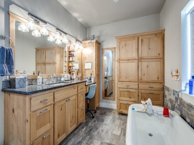 bathroom featuring wood-type flooring, vanity, a bathtub, and a wealth of natural light