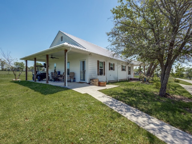 view of front of home with a front lawn, ceiling fan, and a patio