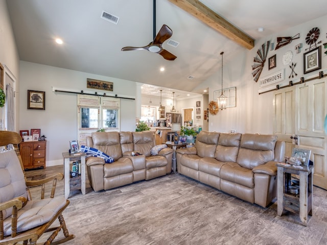 living room featuring a barn door, high vaulted ceiling, ceiling fan with notable chandelier, hardwood / wood-style floors, and beam ceiling