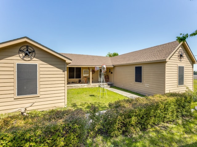 rear view of property featuring a lawn