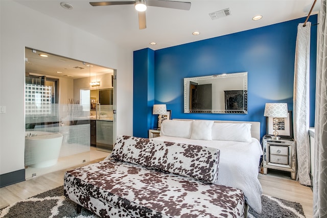 bedroom with light hardwood / wood-style flooring, connected bathroom, and ceiling fan