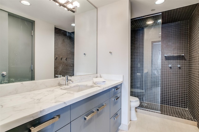bathroom featuring vanity, a tile shower, recessed lighting, toilet, and tile patterned floors