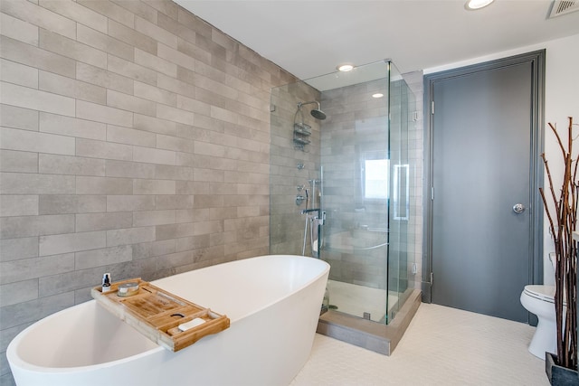 bathroom featuring visible vents, a shower stall, toilet, tile patterned floors, and a freestanding bath