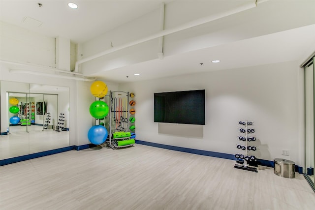 exercise area with baseboards, wood finished floors, and recessed lighting