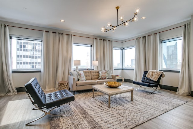living room with an inviting chandelier, baseboards, and wood finished floors