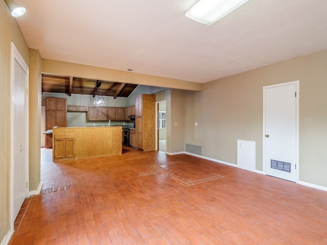 unfurnished living room with beam ceiling