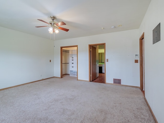 unfurnished bedroom with light colored carpet, connected bathroom, and ceiling fan