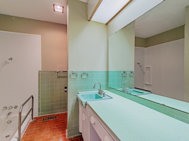 bathroom featuring vanity, tile floors, tasteful backsplash, and tile walls