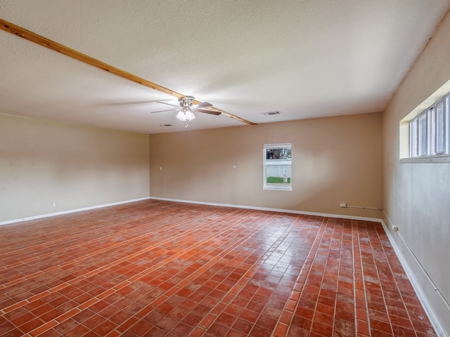 empty room with a textured ceiling and ceiling fan