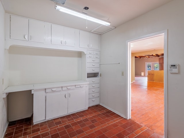 kitchen with dark tile flooring and white cabinets