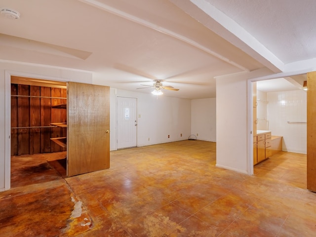 interior space with ceiling fan, light tile floors, and beamed ceiling