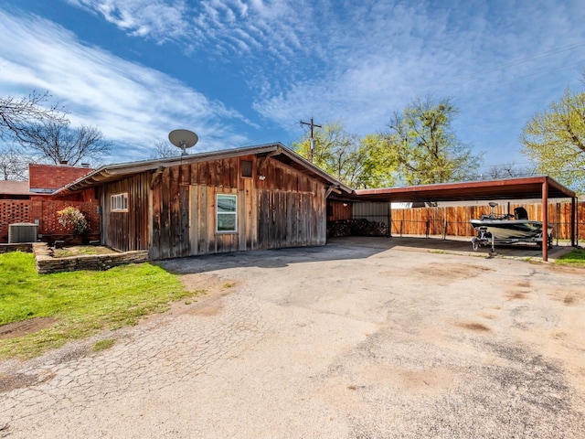 view of front of property with central AC and a carport