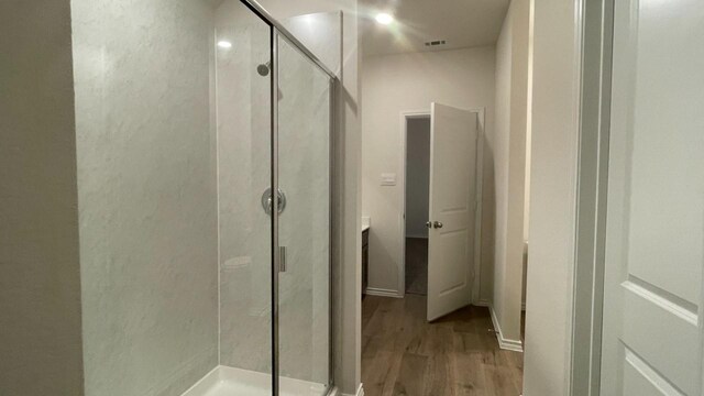 bathroom with vanity, a shower with door, and hardwood / wood-style flooring